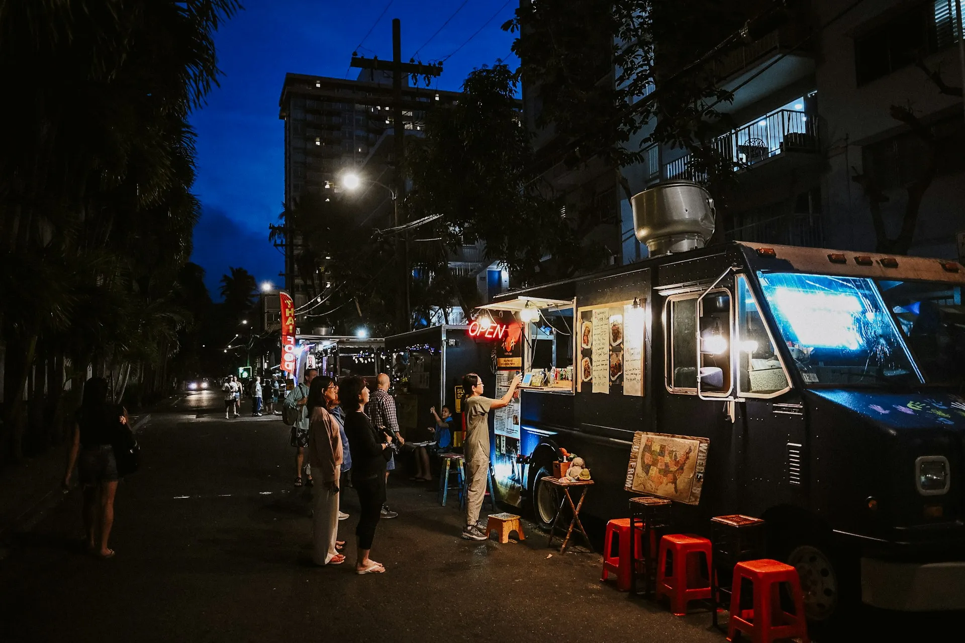 Gäste bestellen am Abend an einem beleuchteten Foodtruck